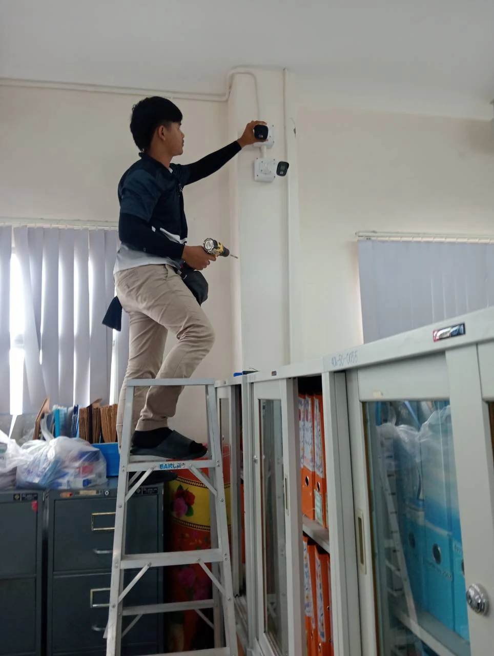 ช่างติดตั้งกล้องวงจรปิดบนผนังสำนักงานกองคลัง เทศบาลเมืองกระบี่